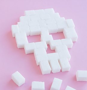 Skull made out of sugar cubes on pink background | common health myths